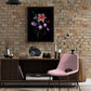 A framed dark botanical print of colourful Dahlias, Cosmos, Asters and Mallow on a black background, hung on a light brick wall.